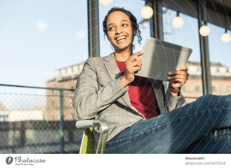 Happy young businesswoman using a tablet at the window in office Occupation Work job jobs profession professional occupation human human being human beings