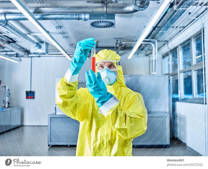 Chemist working in industrial laboratory, checking test tube chemist At Work Protective Suit Chemical Laboratory natural scientist science sciences scientific