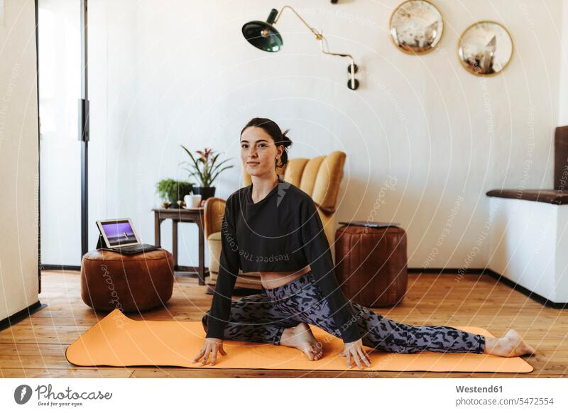 Young woman practicing yoga at home chairs Arm Chair Arm Chairs armchairs relax relaxing smile exercise exercising practice practise practising content