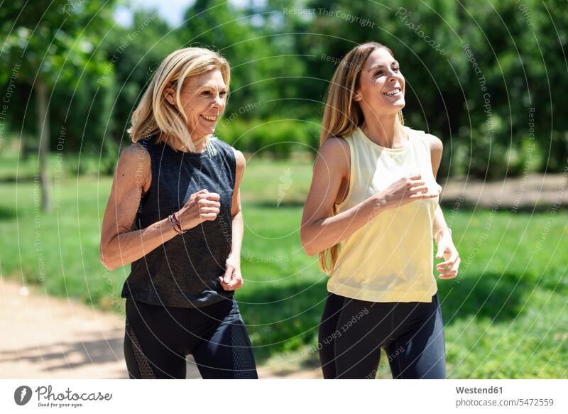 Mature woman running with her daughter in a park human human being human beings humans person persons caucasian appearance caucasian ethnicity european 2
