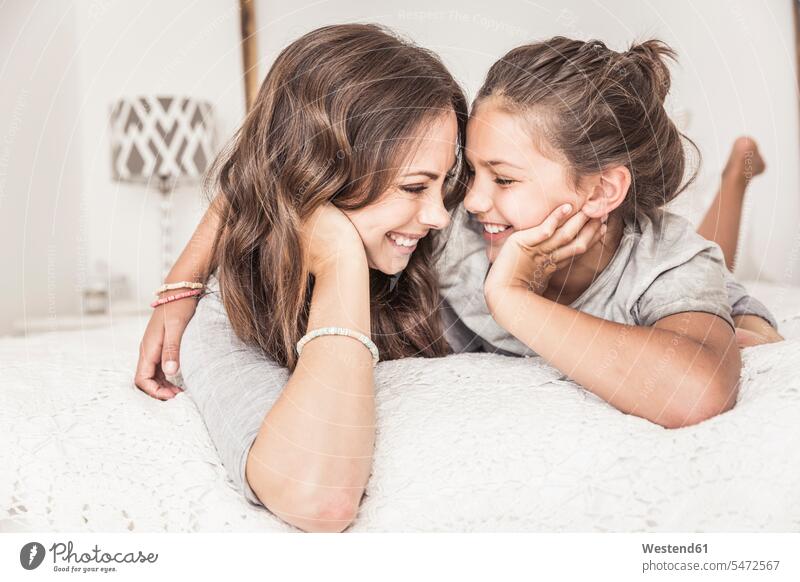 Happy mother and daughter lying together on bed having fun human human being human beings humans person persons caucasian appearance caucasian ethnicity