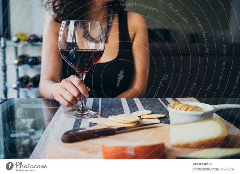 Young woman holding wineglass while sitting at dining table color image colour image indoors indoor shot indoor shots interior interior view Interiors
