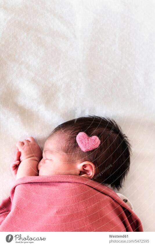 Newborn baby girl with heart shape on head sleeping over bed in hospital color image colour image Spain indoors indoor shot indoor shots interior interior view