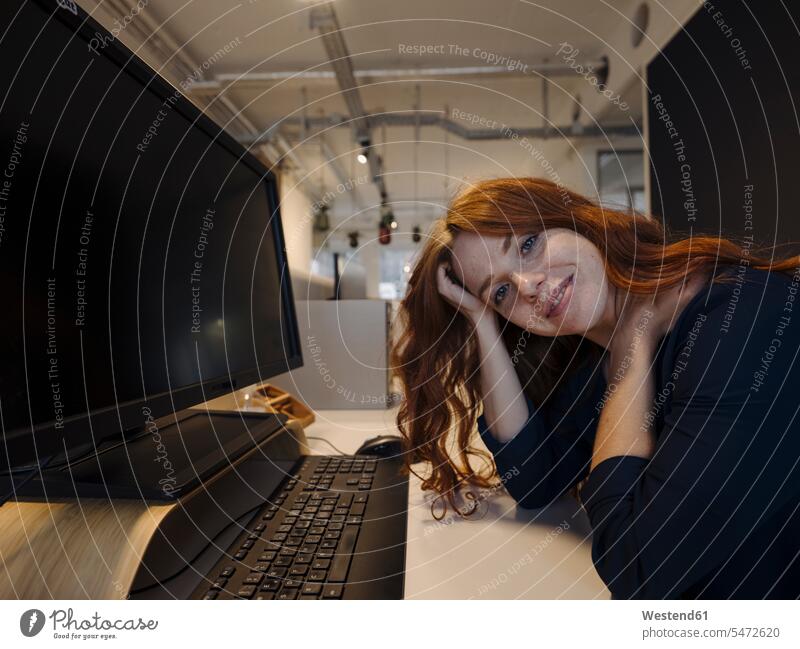 Portrait of smiling redheaded woman sitting at desk in office human human being human beings humans person persons caucasian appearance caucasian ethnicity