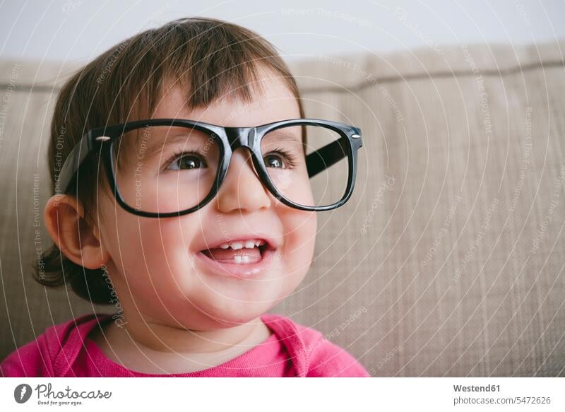 Portrait of laughing baby girl wearing oversized glasses Laughter portrait portraits specs Eye Glasses spectacles Eyeglasses humongous gigantic giant enormous