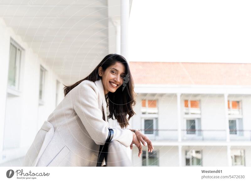 Portait of happy young woman on balcony bags hand-bag hand-bags handbags smile relax relaxing relaxation delight enjoyment Pleasant pleasure Cheerfulness