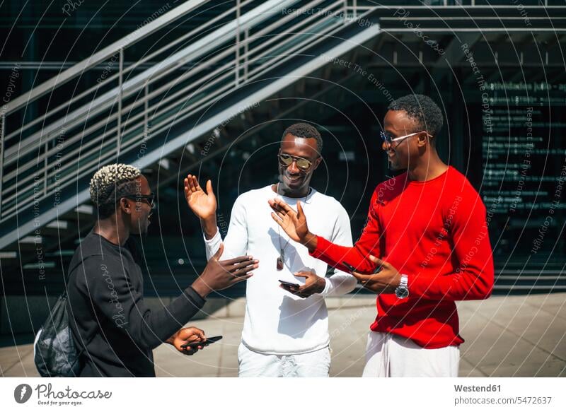 Three cool young men with cell phones meeting in the city human human being human beings humans person persons African black black ethnicity coloured Group