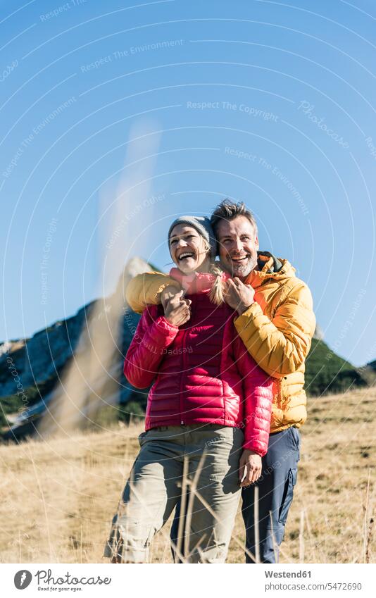 Austria, Tyrol, happy couple embracing on a hiking trip in the mountains mountain range mountain ranges twosomes partnership couples happiness hike embrace