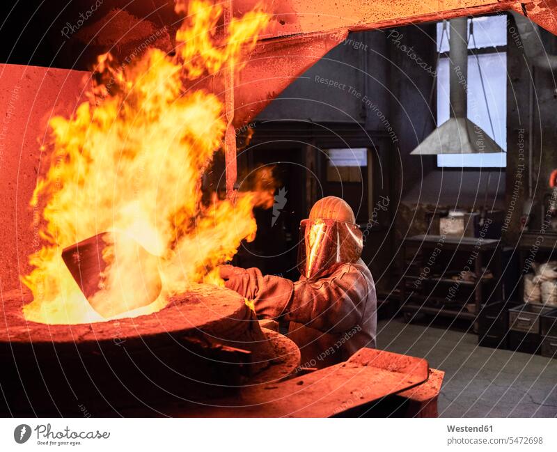 Industry, worker at furnace during melting copper, wearing a fire proximity suit copy space one man only only one man 1 1 man one man alone standing workwear
