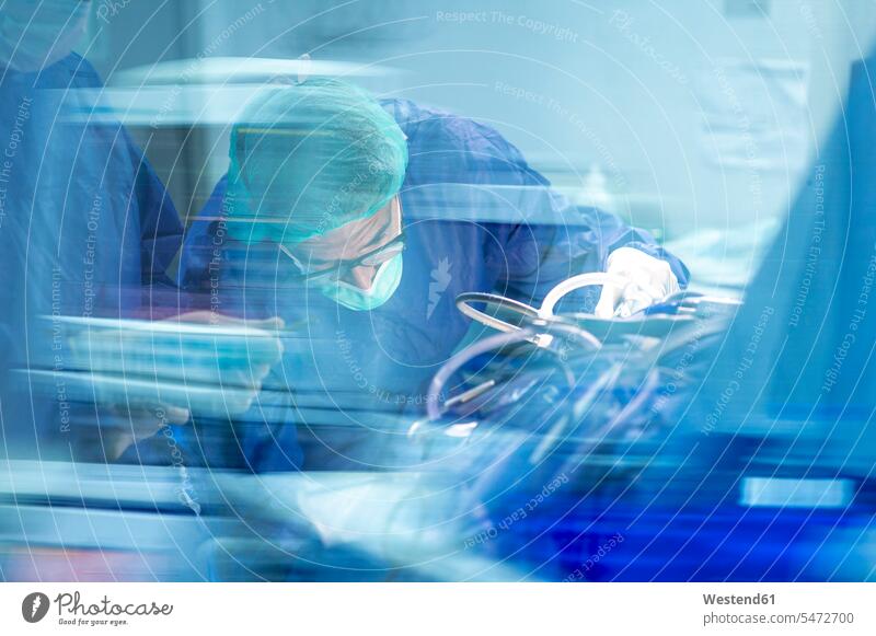 Focused male orthopedic surgeon operating with coworker in ICU color image colour image indoors indoor shot indoor shots interior interior view Interiors