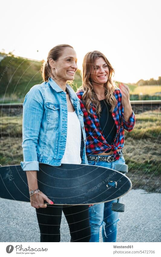 Two smiling friends with longboard female friends smile Longboard mate friendship wipe effect beautiful toothy smile big smile open smile laughing togetherness