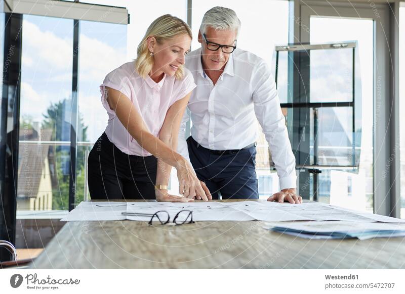 Businessman and woman discussing project in office discussion Office Offices projects Female Colleague toothy smile big smile open smile laughing expertise