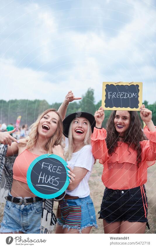 Happy women at the music festival with signs, free hugs, freedom female friends happiness happy music festivals smiling smile Peace peacefulness mate friendship