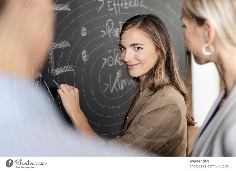 Young businesswoman brainstorming at blackboard in office human human being human beings humans person persons caucasian appearance caucasian ethnicity european