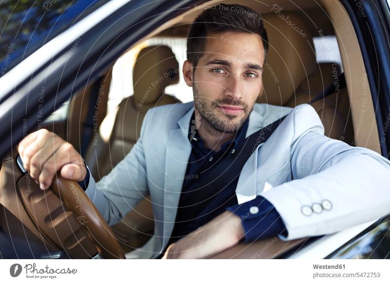 Successful young businessman driving in his car Businessman Business man Businessmen Business men automobile Auto cars motorcars Automobiles on the move