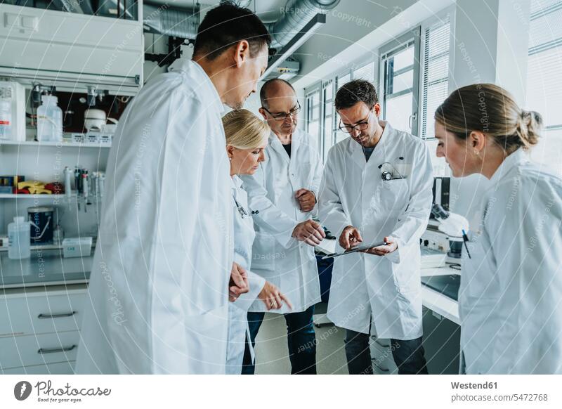 Scientist working with digital tablet while standing at laboratory color image colour image indoors indoor shot indoor shots interior interior view Interiors