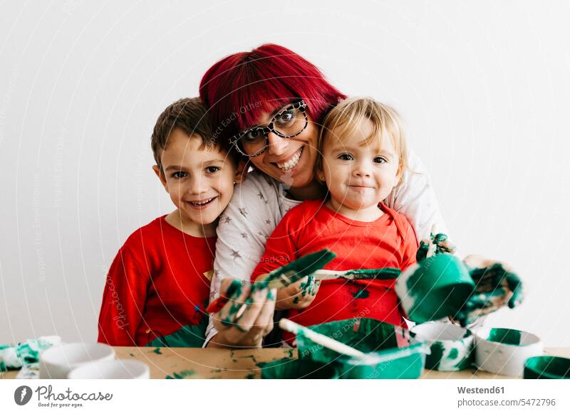 Mother with her children doing crafts at home and painting with green human human being human beings humans person persons caucasian appearance