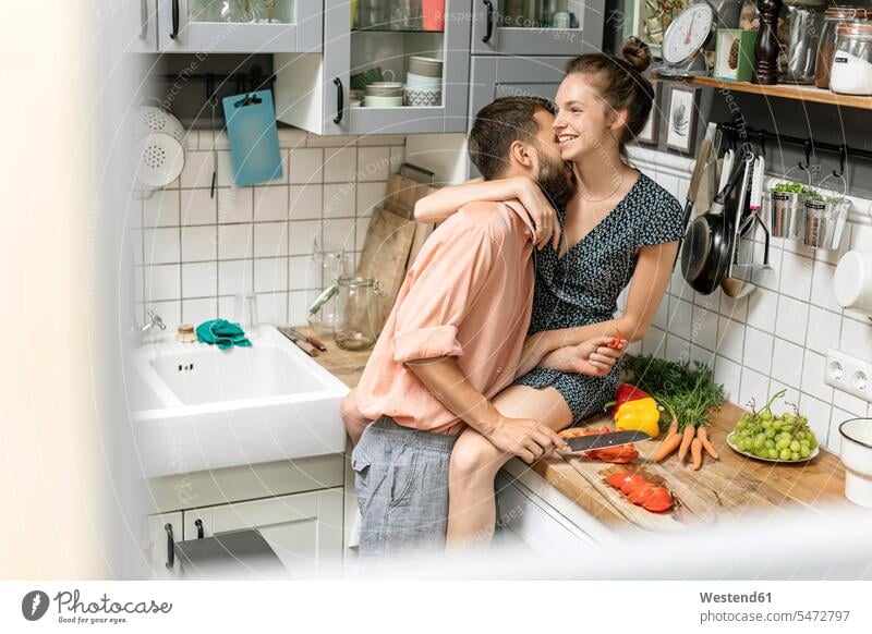 Affectionate couple in kitchen, preparing food rack racks Shelve shelves kiss kisses Emotions Feeling Feelings Sentiment Sentiments loving closeness propinquity