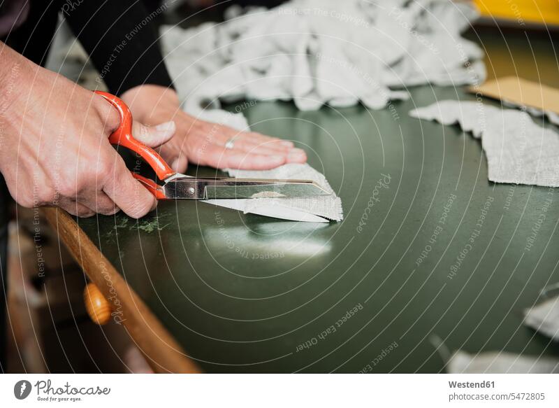Close up of woman's hand cutting a fabric with scissor Occupation Work job jobs profession professional occupation blue collar blue collar worker