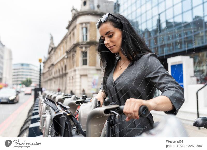Woman in the city using bicycle hire for commuting, London, UK human human being human beings humans person persons caucasian appearance caucasian ethnicity