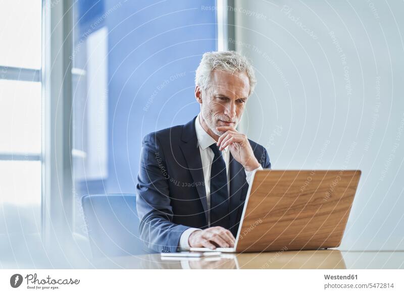 Focused businessman using laptop at desk in office Occupation Work job jobs profession professional occupation business life business world business person