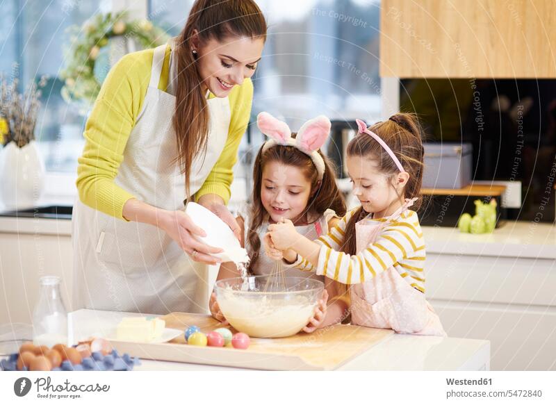 Mother and daughters baking Easter cookies in kitchen together bake mother mommy mothers ma mummy mama Biscuit Cookie Cooky Cookies Biscuits celebration
