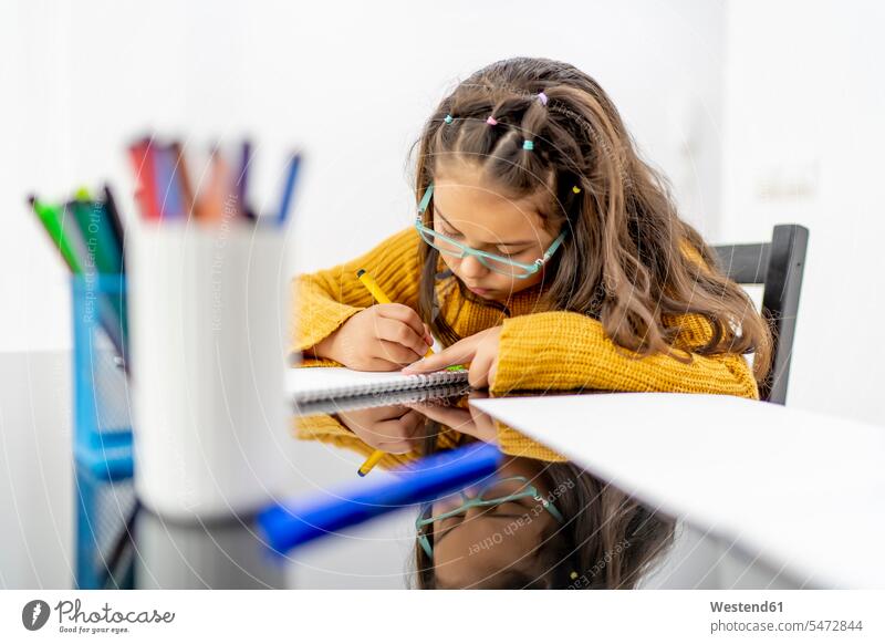 Girl drawing in book on table at home color image colour image indoors indoor shot indoor shots interior interior view Interiors 8-9 years 8 to 9 years children
