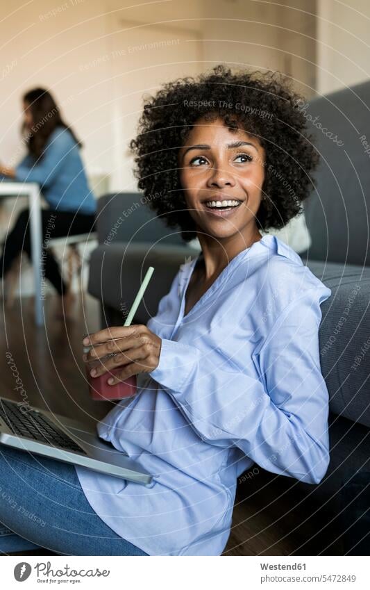 Happy woman with soft drink sitting on floor using laptop floors females women refreshing drink soft drinks refreshing drinks Seated smiling smile