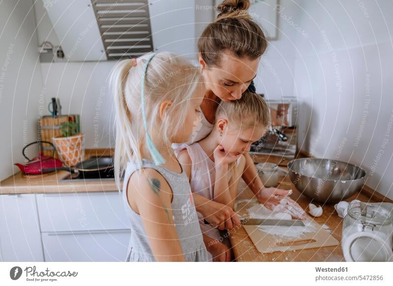 Mother with daughters preparing cheesecake in kitchen at home color image colour image Germany Home Interior Home Interiors domestic space domestic kitchen