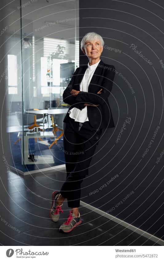 Portrait of fashionable senior businesswoman wearing pantsuit and sneakers in office business life business world business person businesspeople business woman