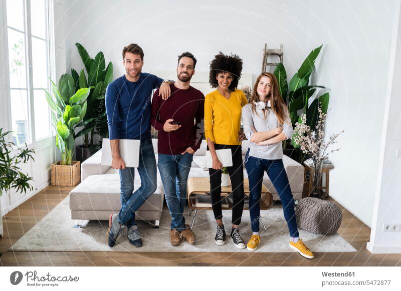 Portrait of four happy friends standing side by side in living room human human being human beings humans person persons caucasian appearance