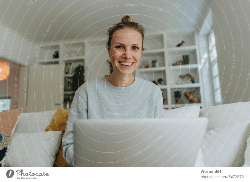 Woman smiling while working on laptop at home color image colour image indoors indoor shot indoor shots interior interior view Interiors day daylight shot