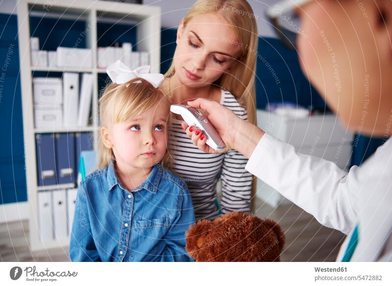 Doctor taking girl's temperature in medical practice examining checking examine medical practices Doctors Office Doctor's Office mother mommy mothers ma mummy