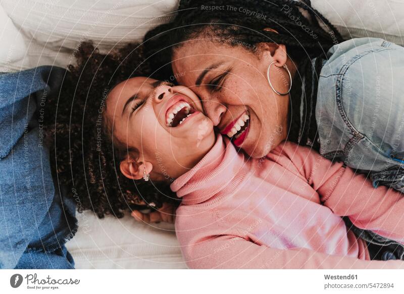 Portrait of laughing little girl and her mother having fun together at home human human being human beings humans person persons 2 2 people 2 persons two