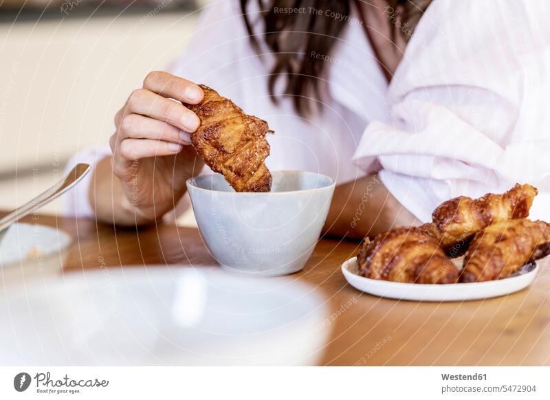 Close-up of woman dipping a croissant into coffee cup human human being human beings humans person persons caucasian appearance caucasian ethnicity european 1