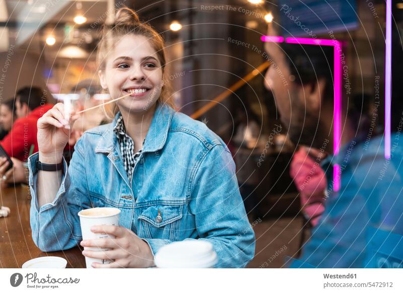 Portrait of smiling young woman in a coffee shop looking at young man windows pane panes window glass window glasses Window Pane windowpanes flirt Flirtation