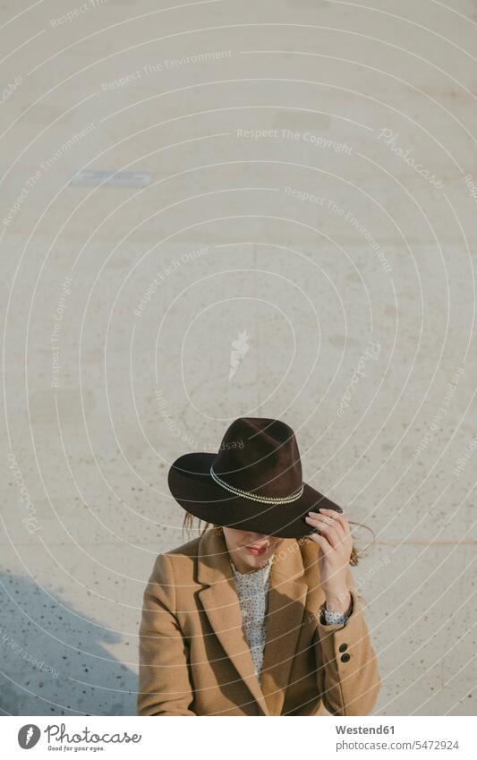 Young hipster woman with a hat hats females women Hipster Hipsters obscured face obscured faces face hidden Coat Coats floor floors sitting Seated Adults
