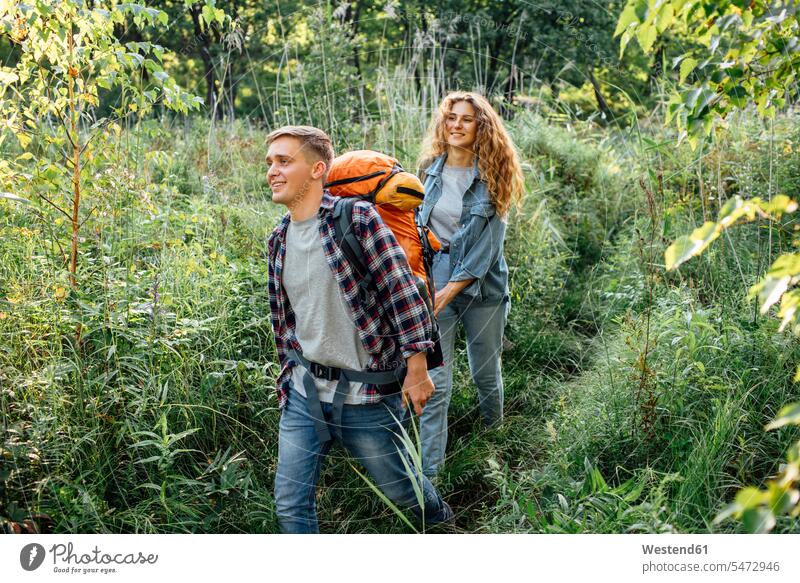 Young couple hiking together in nature young couple young couples young twosome young twosomes hike walking going backpack rucksacks backpacks back-packs