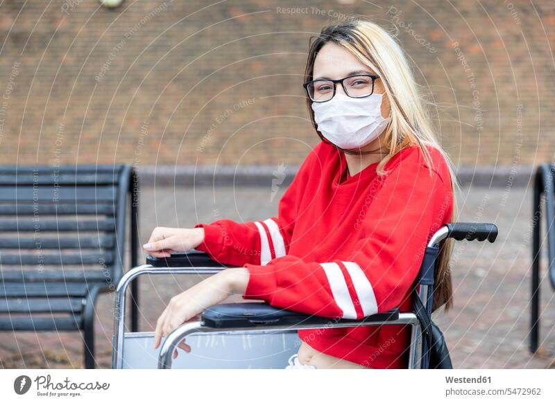 Disabled woman on wheelchair wearing face mask during coronavirus outbreak color image colour image outdoors location shots outdoor shot outdoor shots day