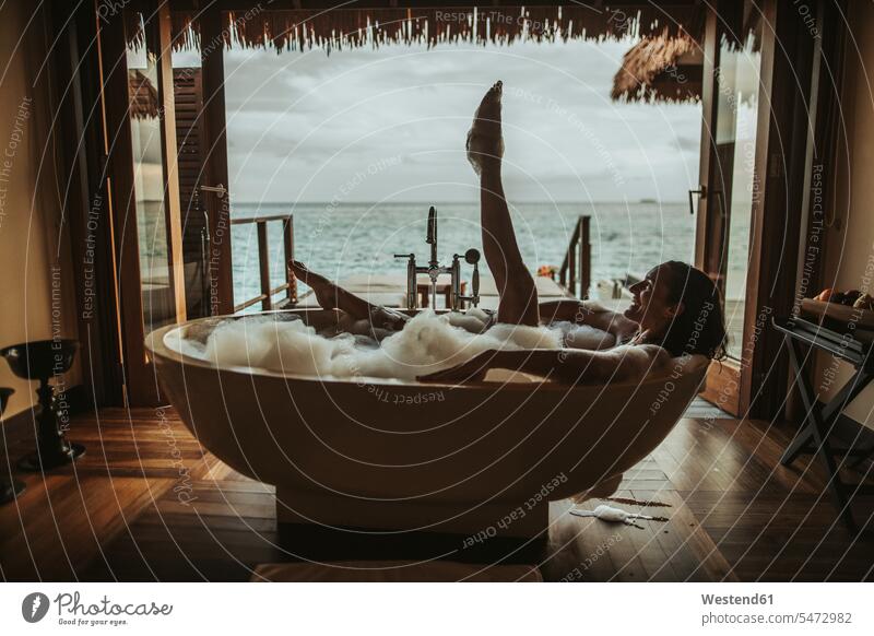 Woman relaxing in bathtub with view to the sea, Maguhdhuvaa Island, Gaafu Dhaalu Atoll, Maldives bath tub bath tubs bathtubs bathe Taking A Bath smile