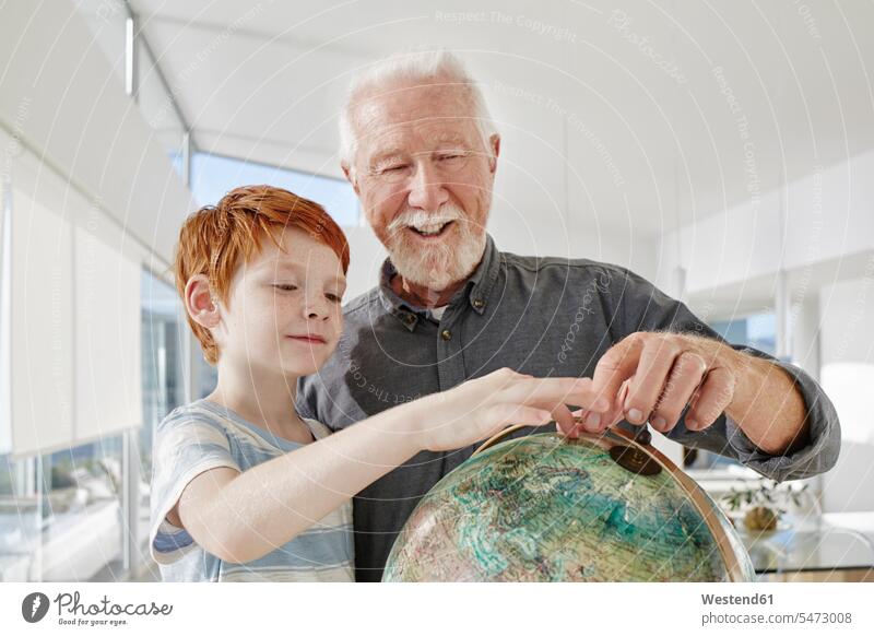 Grandfather and grandson looking at globe in a villa generation globes find smile delight enjoyment Pleasant pleasure indulgence indulging savoring happy