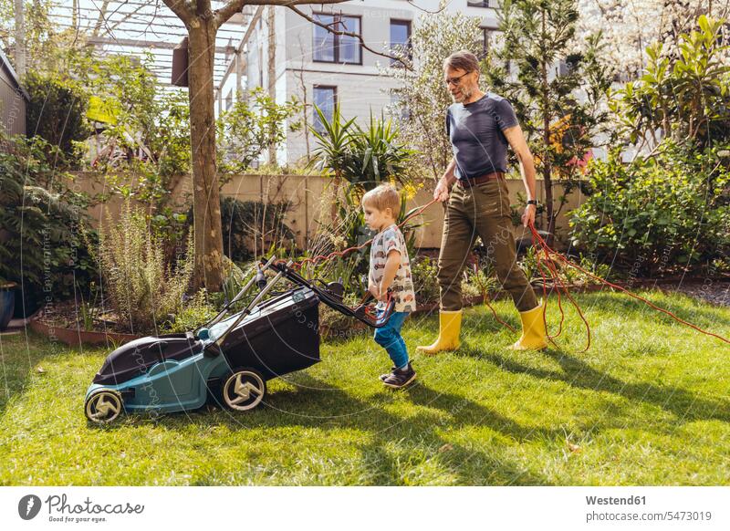 Father and son mowing the lawn together T- Shirt t-shirts tee-shirt lawnmower At Work work learn seasons summer time summertime summery free time leisure time