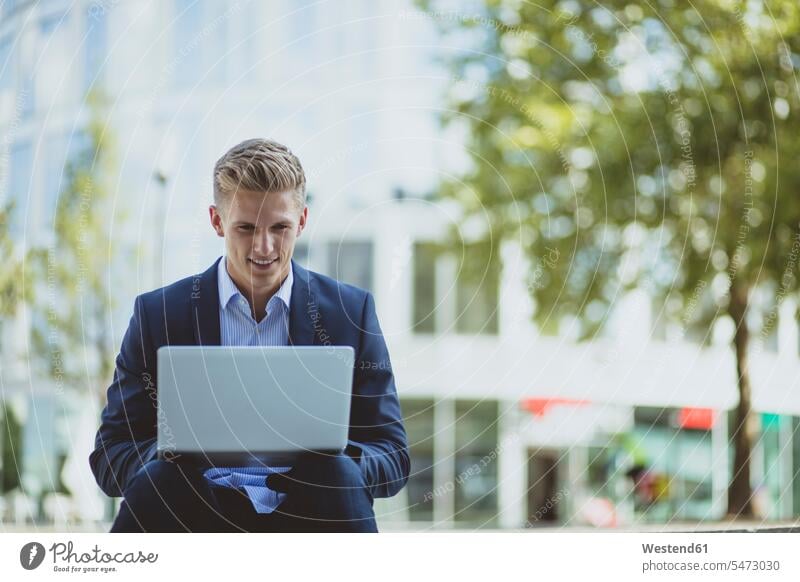 Young businessman using laptop in the city Occupation Work job jobs profession professional occupation business life business world business person