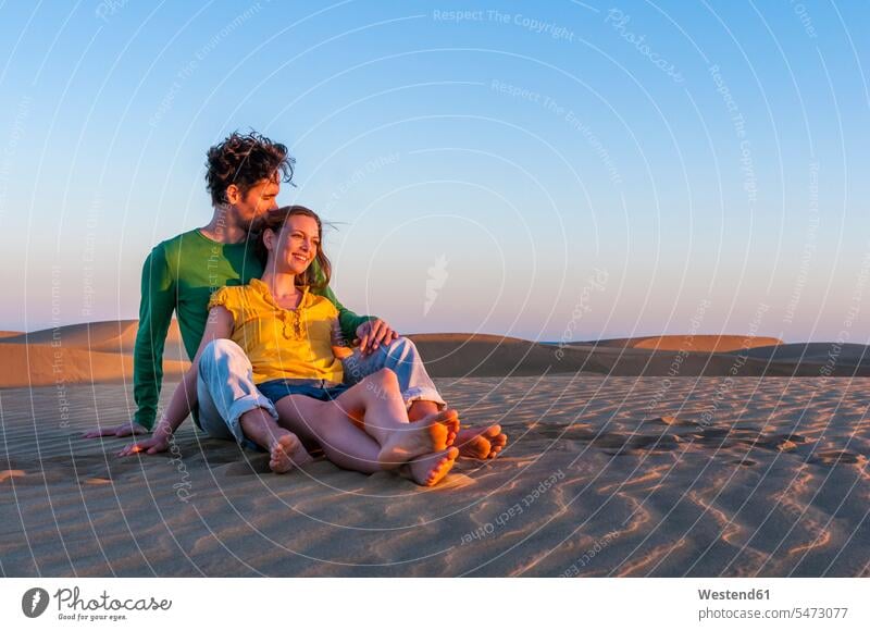 Affectionate couple sitting in the dunes at sunset, Gran Canaria, Spain human human being human beings humans person persons caucasian appearance