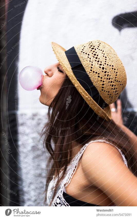 Profile of young woman blowing pink bubble gum gum bubble females women profile Profile View profiles Chewing Gum Chewing Gums Rosy Adults grown-ups grownups