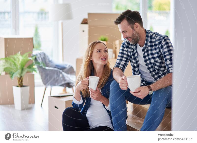 Man and pregnant woman moving into new flat having a coffee break flats apartment apartments move in couple twosomes partnership couples Coffee Pregnant Woman