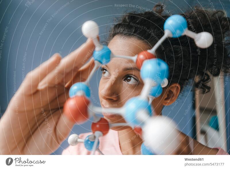 Female scientist holding molecule model, looking for solutions female scientists woman females women molecular model Solutions science sciences scientific
