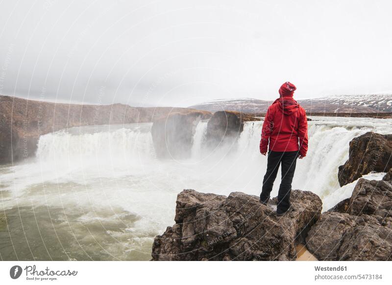 Iceland, man standing at Godafoss waterfall looking watching waterfalls men males view seeing viewing waters body of water Adults grown-ups grownups adult