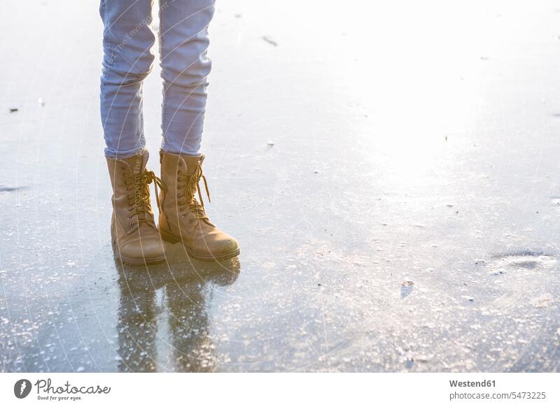 Germany, Brandenburg, Lake Straussee, feet with boots on frozen lake warm clothing Winter Clothes Winterwear Winter Wear Winter Clothing leisure free time