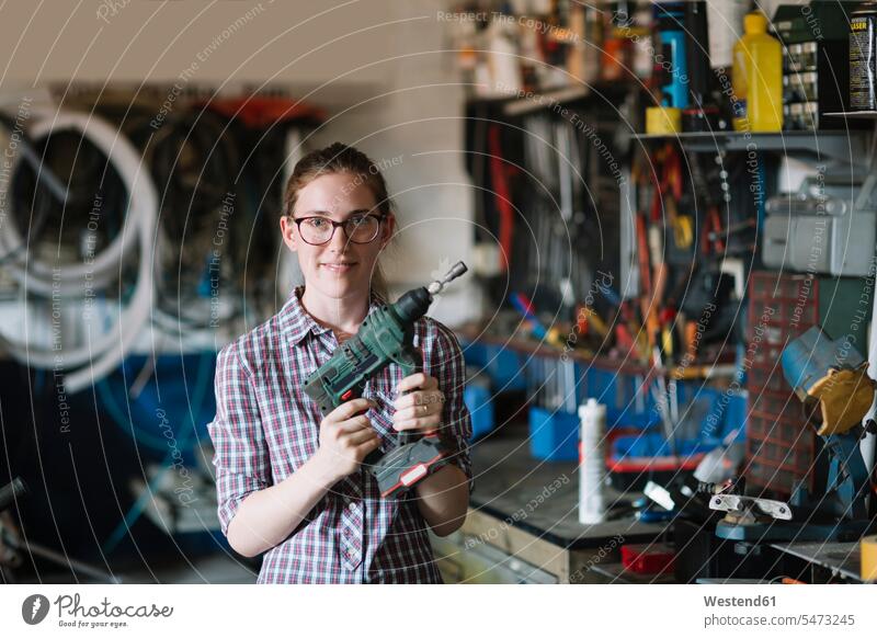 Portrait of confident womanholding drill in her workshop human human being human beings humans person persons caucasian appearance caucasian ethnicity european